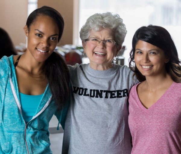 Elderly woman and two younger volunteer woman.