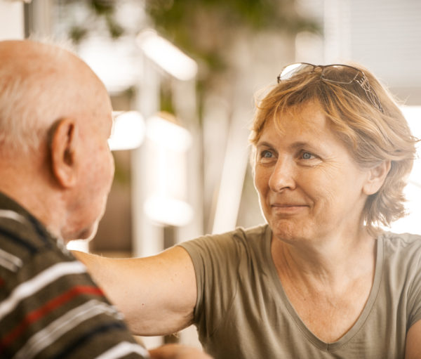 elder daughter visiting father in memory care community