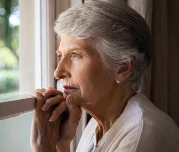 Elderly woman looking out window