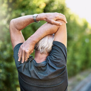 Rear view shot of a senior man warming up before a run outside